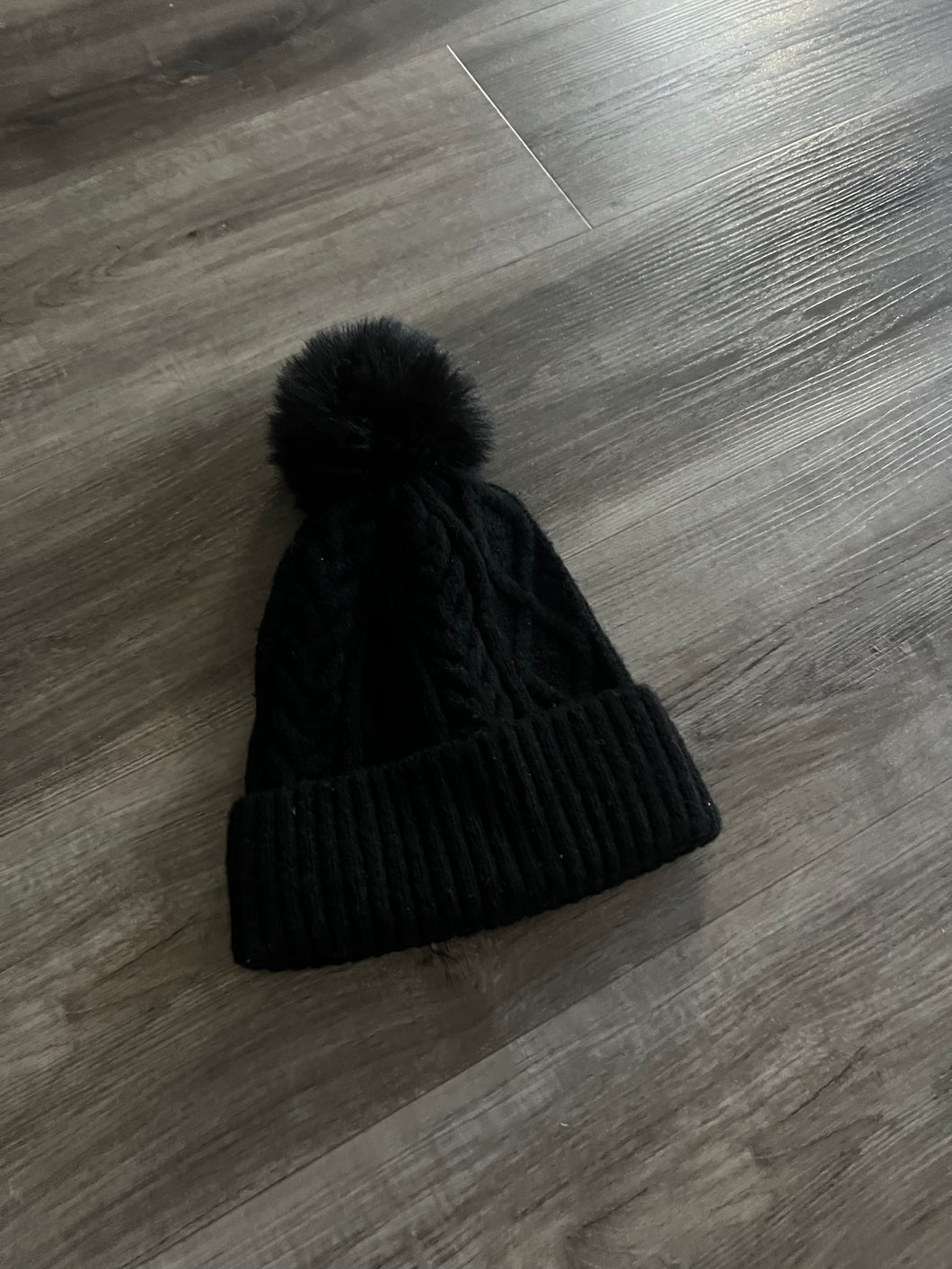 Black knit beanie with puffball
